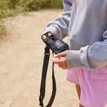 24oz Onyx Bottle Sling held by a female on a trail