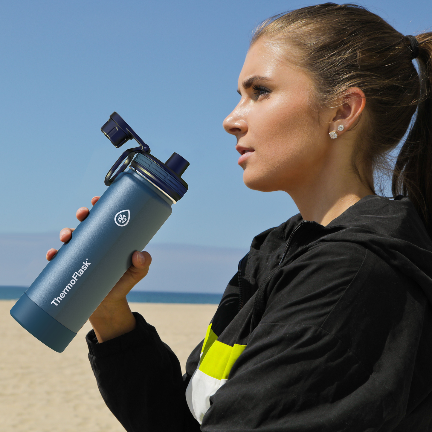 One Size Black Spout Lid. Female holding ThermoFlask bottle to show spout lid.