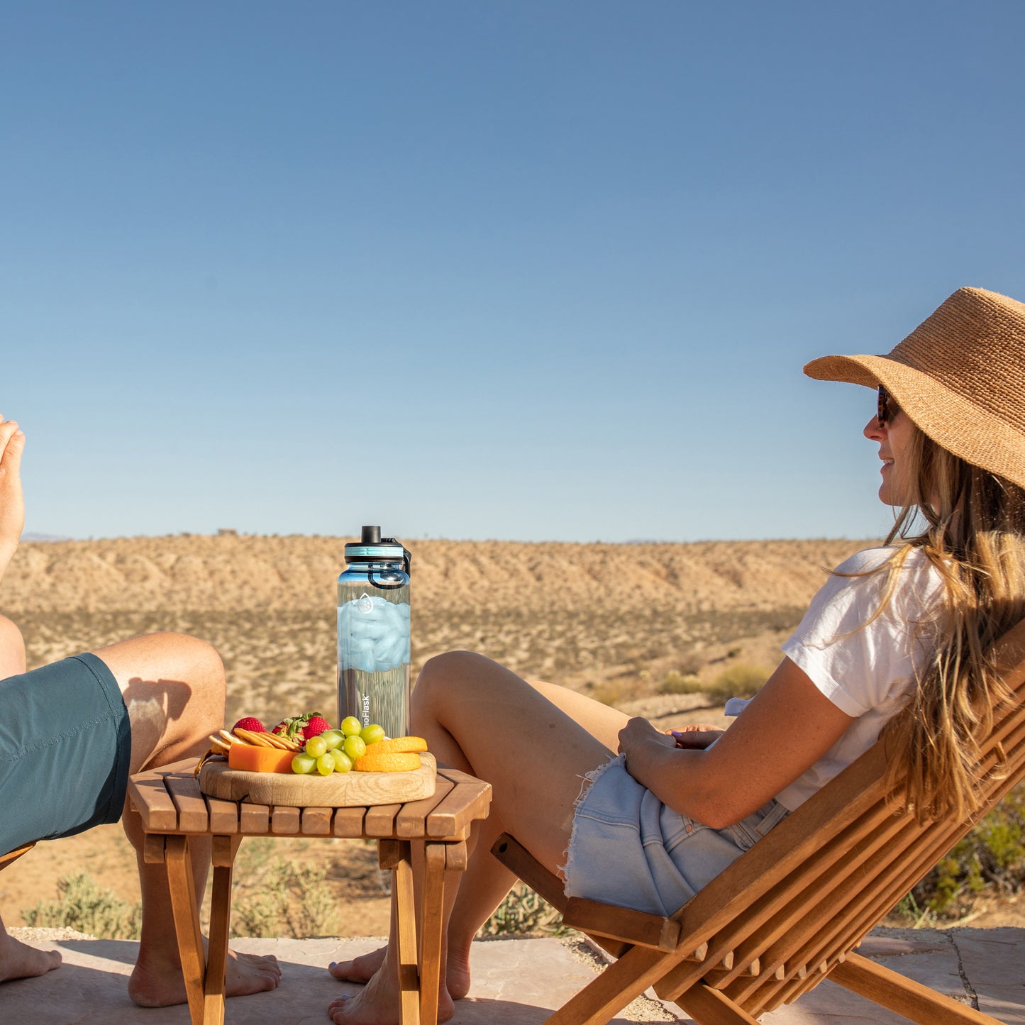 40oz Sky Tritan Bottle sitting on a table by a woman.