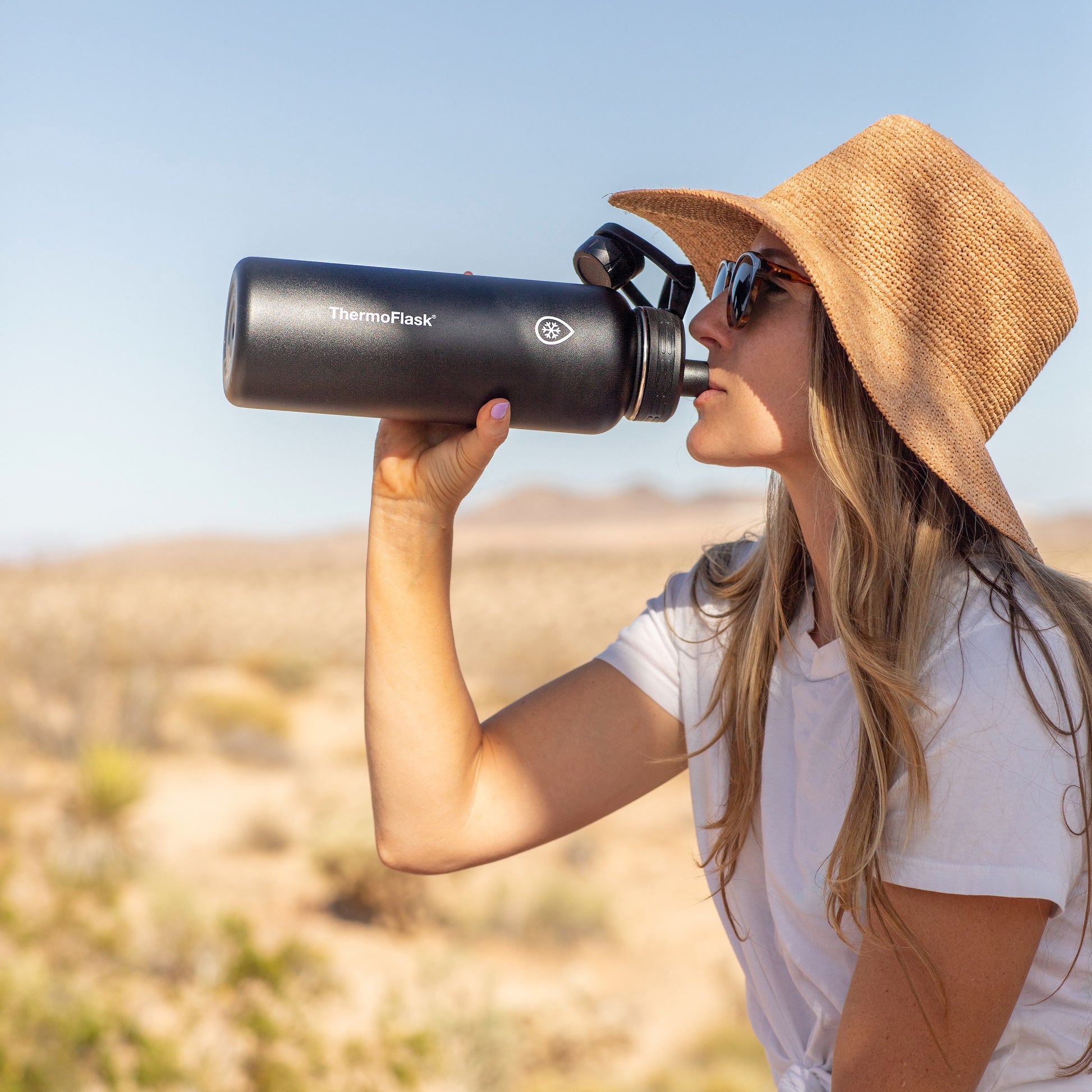 40oz Onyx chug bottle held by a woman drinking.